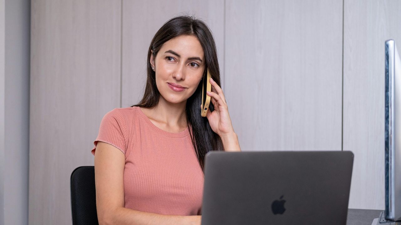 persona al telefono di fronte al computer