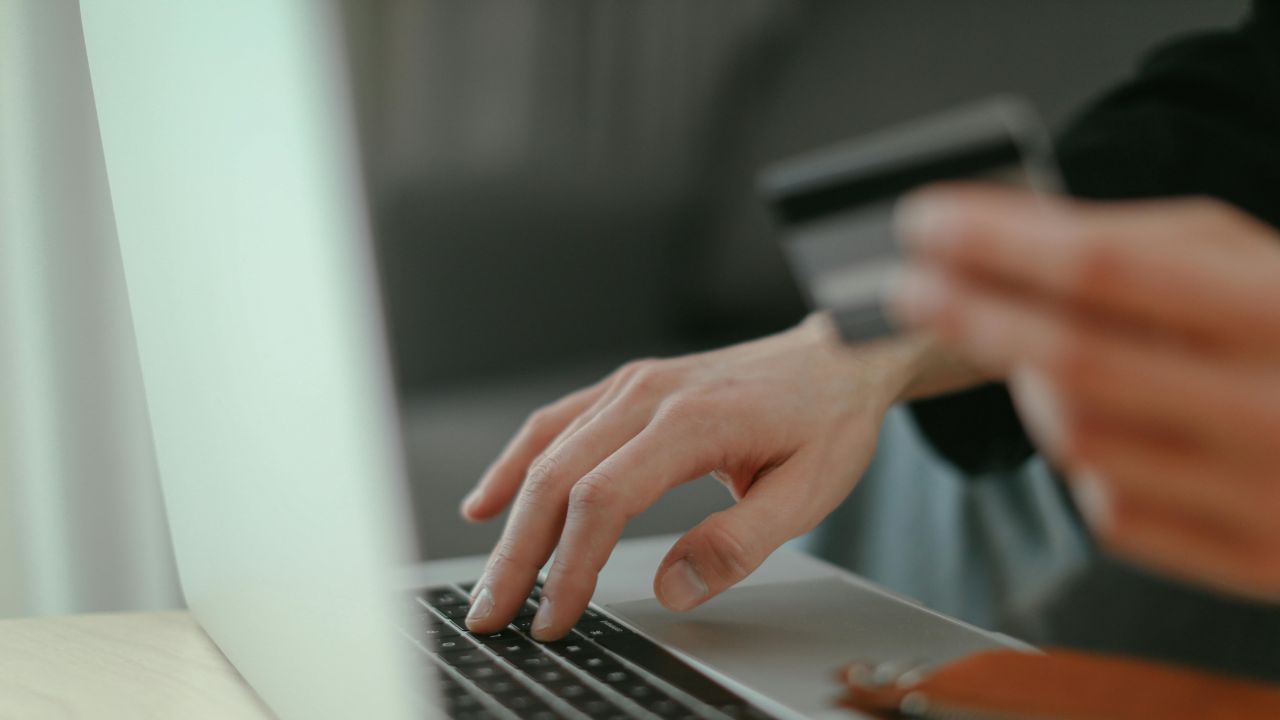 persona usa carta di pagamento al computer